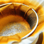 fotografia sobre la importancia de los filtros de cafe en tu taza de expresso para portada de una categoria en una pagina web sobre cafe y cafe expresso y utiliza mucho el color oro b89634 y en men