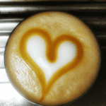 fotografia sobre aprende a hacer un corazon en tu cafe con arte latte para portada de una categoria en una pagina web sobre cafe y cafe expresso y utiliza mucho el color oro b89634 y en menor medid