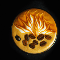 fotografia sobre arte latte de cafe espresso con leche de almendras para portada de una categoria en una pagina web sobre cafe y cafe expresso y utiliza mucho el color oro b89634 y en menor medida