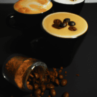 fotografia sobre como hacer un cappuccino con leche de almendras o soja para portada de una categoria en una pagina web sobre cafe y cafe expresso y utiliza mucho el color oro b89634 y en menor med