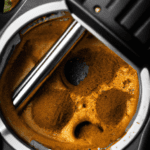 fotografia sobre la limpieza de tu cafetera espresso para portada de una categoria en una pagina web sobre cafe y cafe expresso y utiliza mucho el color oro b89634 y en menor medida el color black