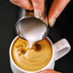 fotografia sobre los secretos detras de un buen arte latte para portada de una categoria en una pagina web sobre cafe y cafe expresso y utiliza mucho el color oro b89634 y en menor medida el color
