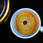 fotografia sobre un cafe descafeinado perfecto en tu cafetera espresso para portada de una categoria en una pagina web sobre cafe y cafe expresso y utiliza mucho el color oro b89634 y en menor medi
